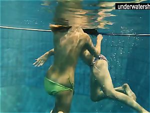 two luxurious amateurs demonstrating their bodies off under water